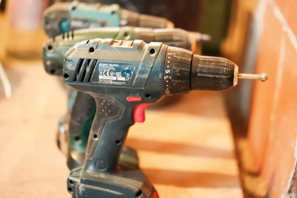 Selection of cordless drills lined up on a workshop bench for a best-of buying guide comparison